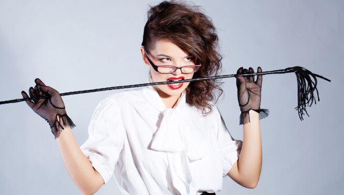 Strict teacher with glasses and a whip